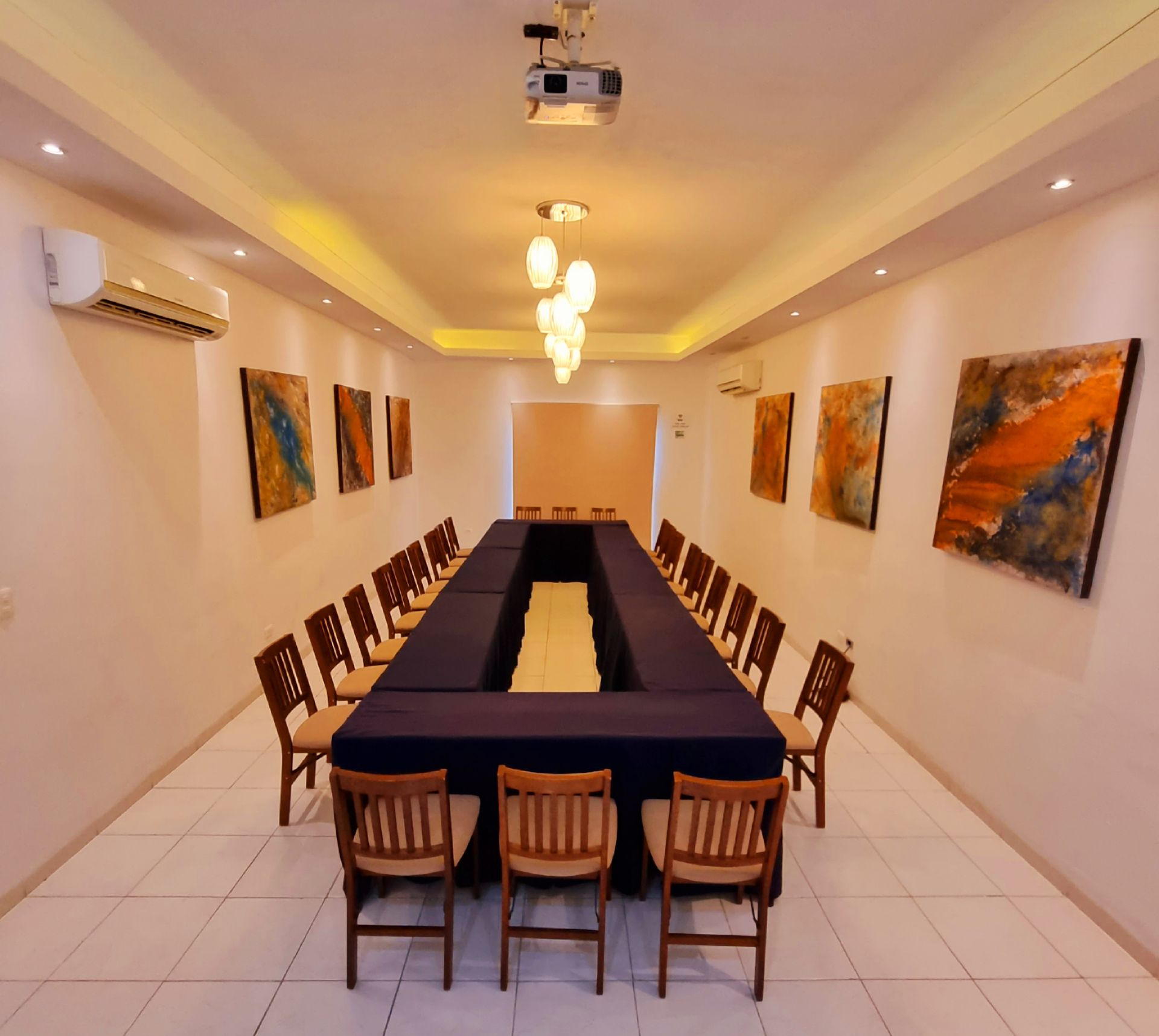 Una sala de conferencias con una mesa larga y sillas.