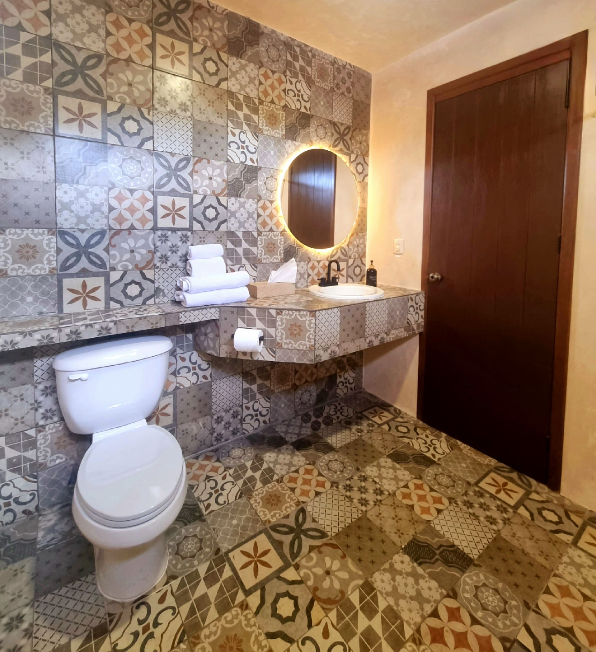 Un baño con inodoro, lavabo y espejo.