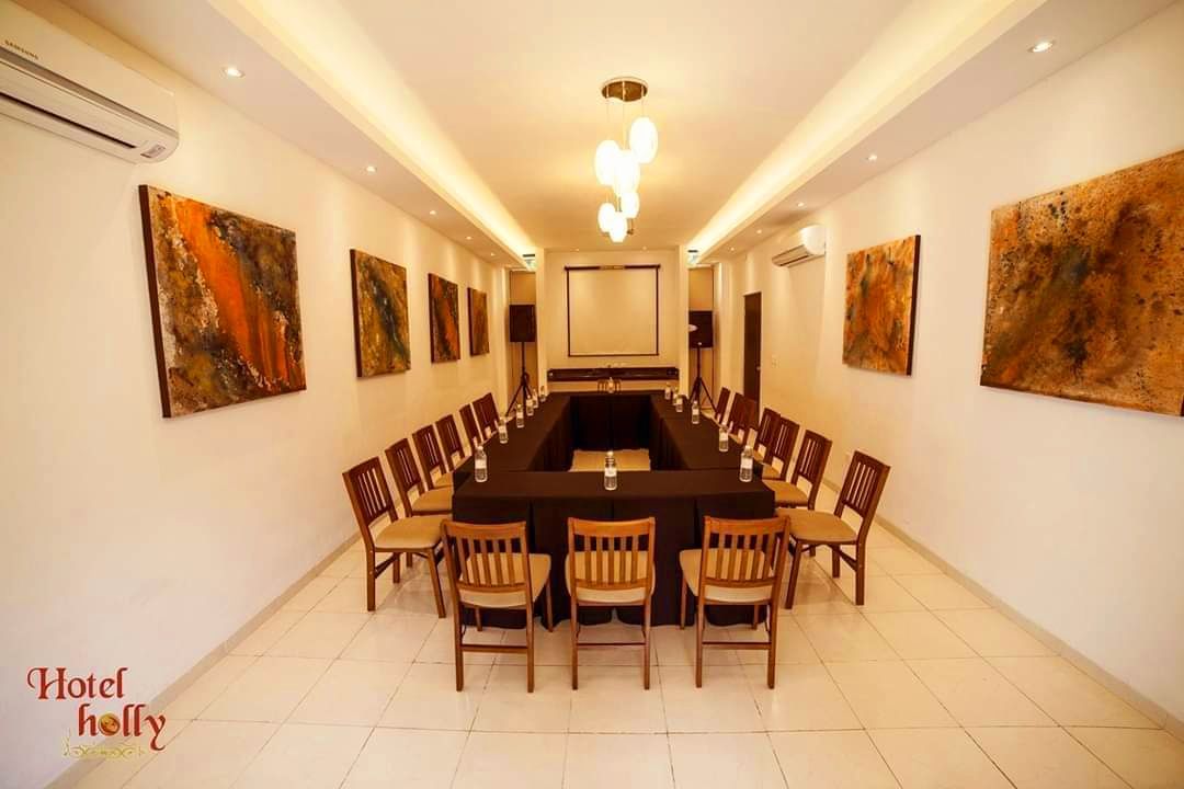 Una sala de conferencias con una mesa larga y sillas.