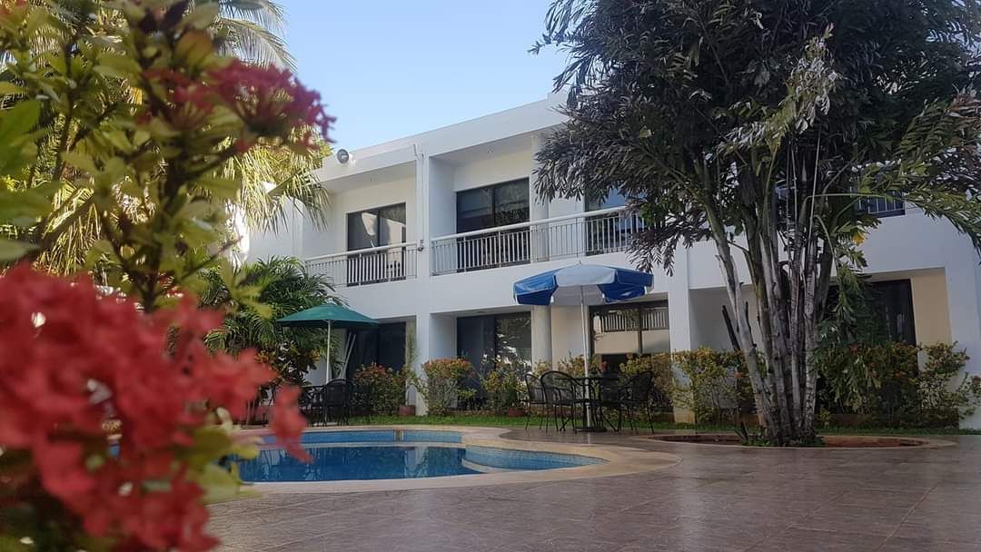 Un edificio blanco con una piscina delante.