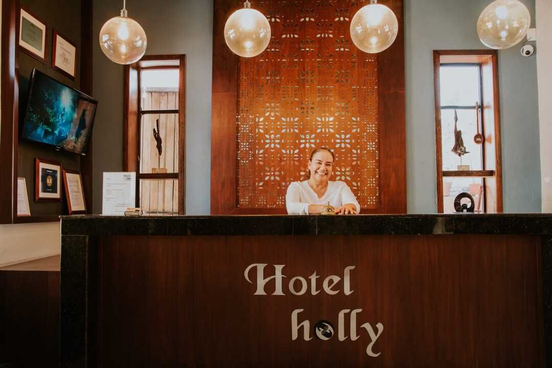 Una mujer está sentada en el mostrador de recepción de un hotel.