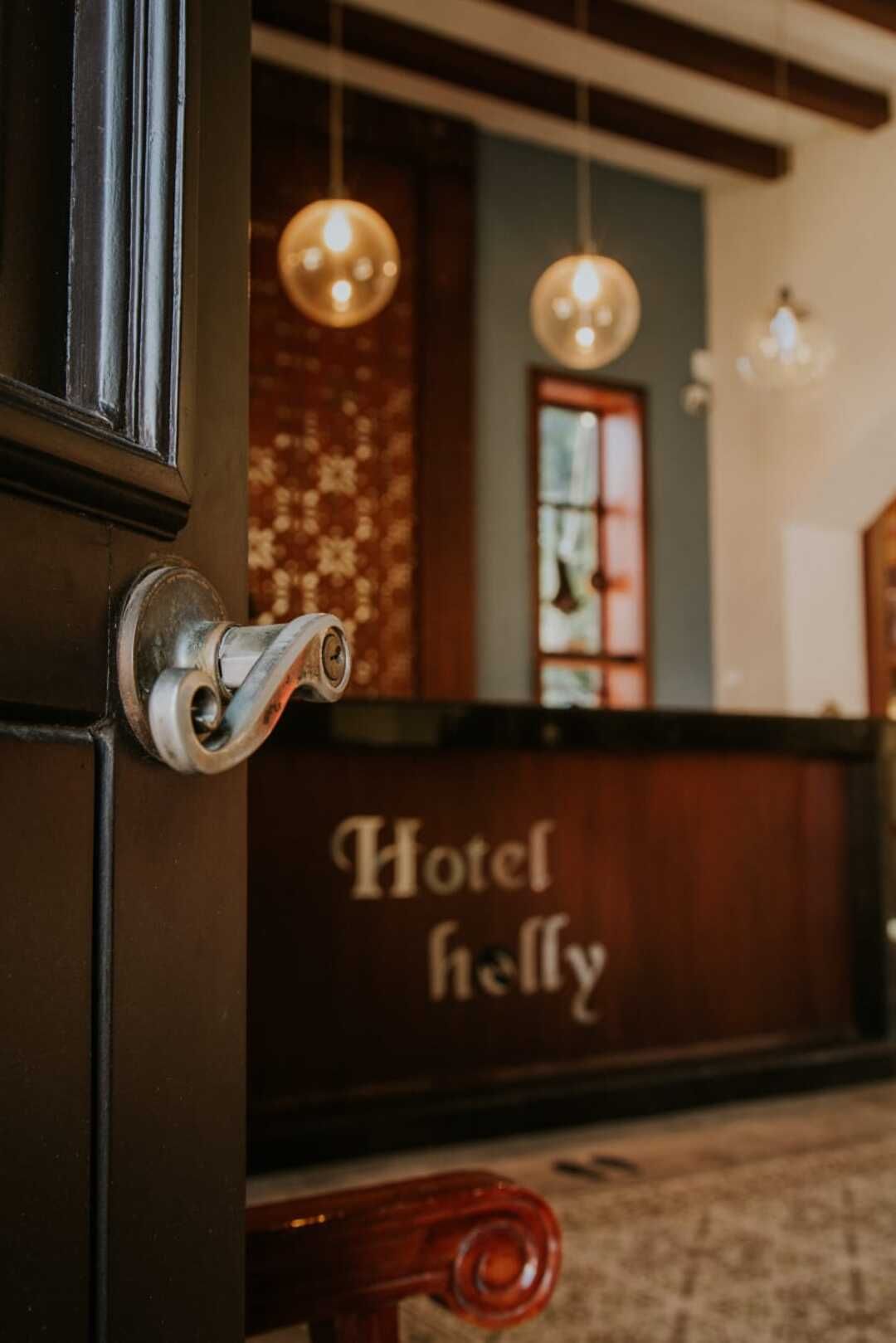 Una puerta está abierta al vestíbulo de un hotel con un mostrador al fondo.