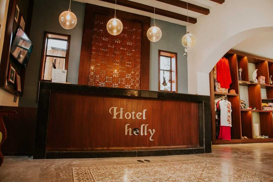 Un vestíbulo de hotel con un mostrador de madera y un cartel que dice Hotel Holly.