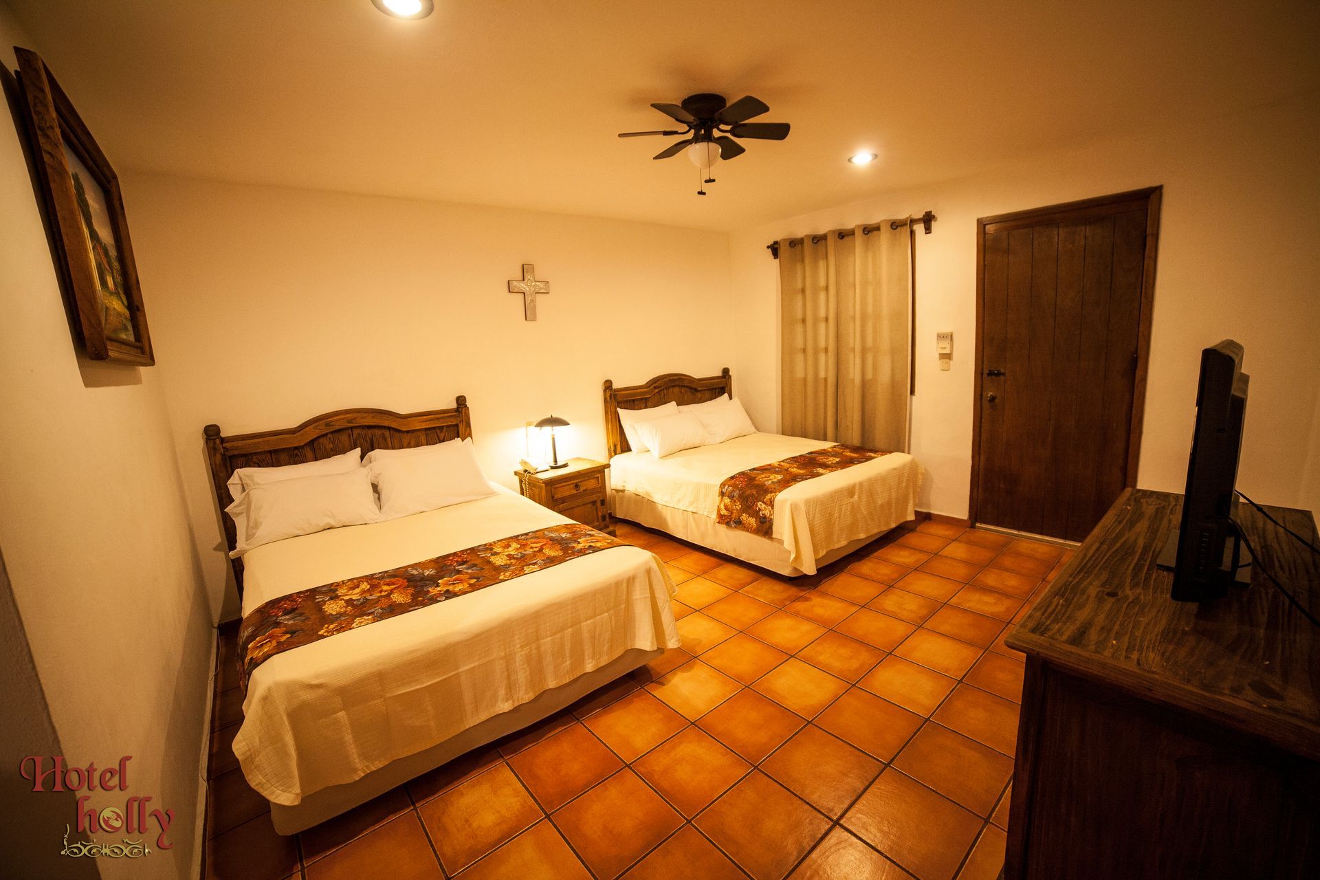 Una habitación de hotel con dos camas y un ventilador de techo.