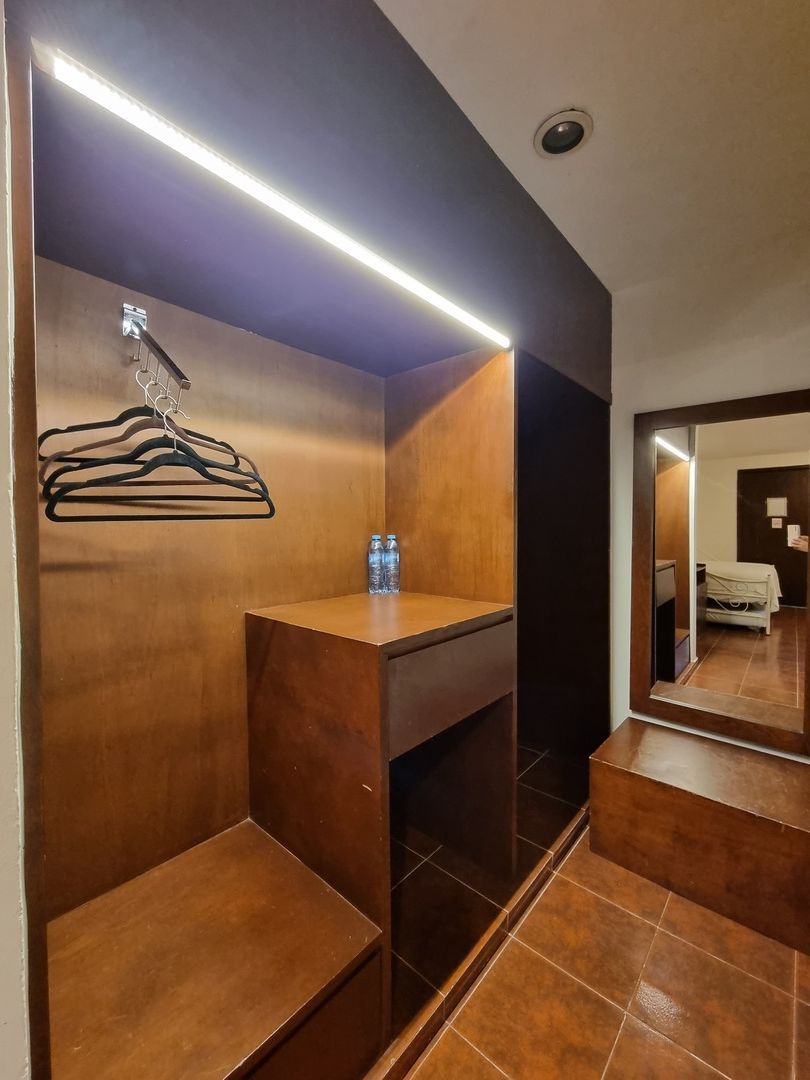 Una habitación de hotel con un armario y un espejo.