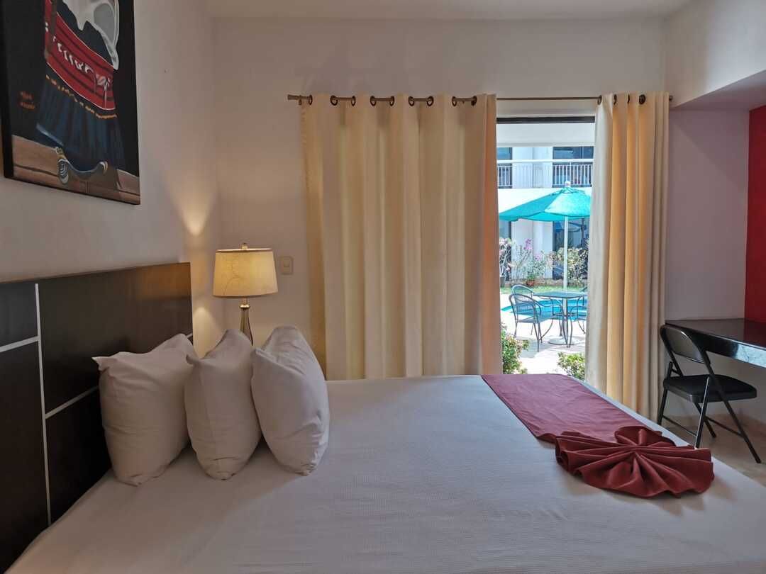 Una habitación de hotel con una cama grande y un cuadro en la pared.