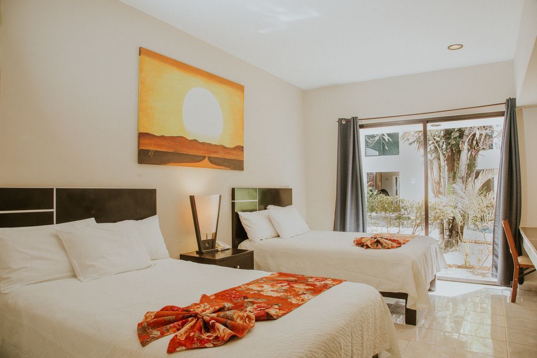 Una habitación de hotel con dos camas y un cuadro en la pared.