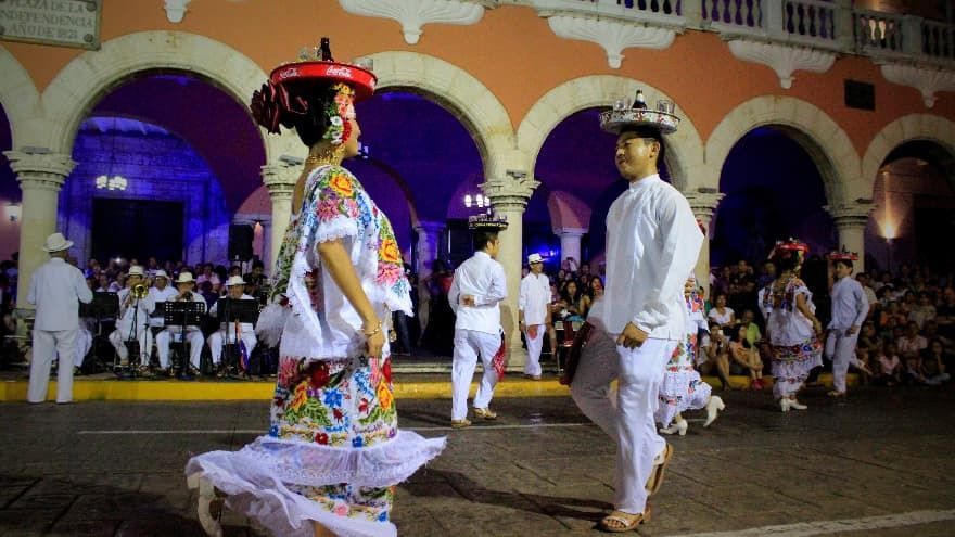 Un hombre y una mujer están bailando delante de una multitud.