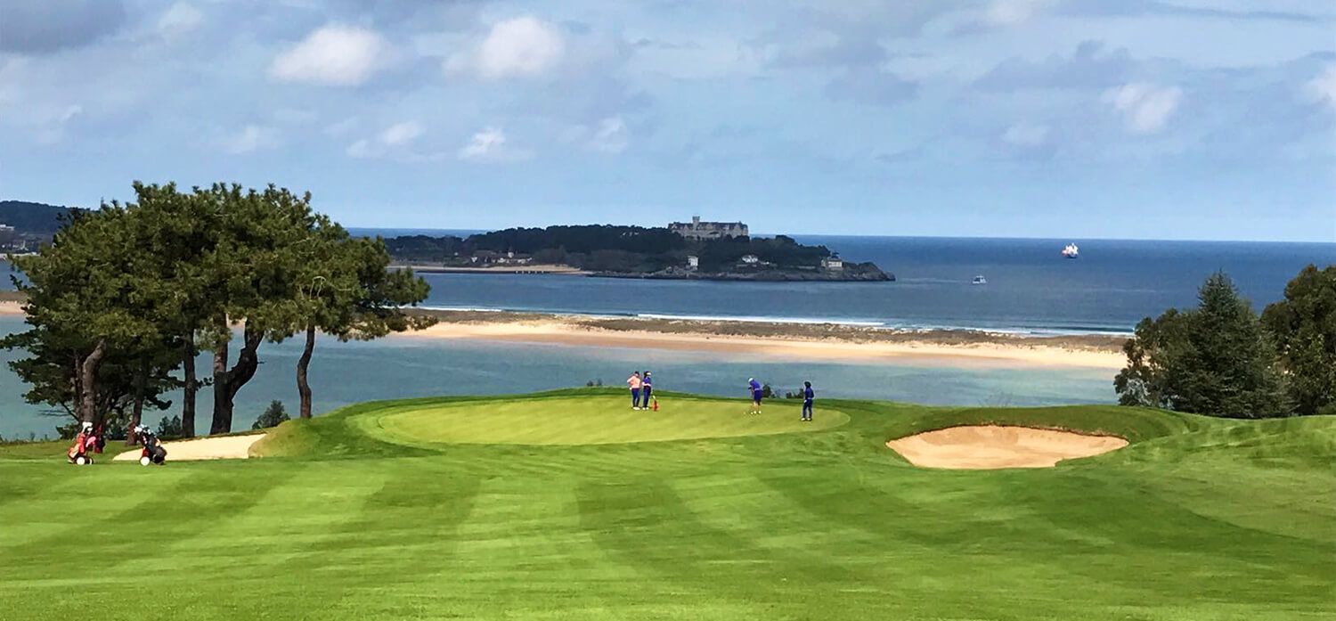 Golfplatz mit Blick auf den blauen Ozean, einem Sandbunker, grünem Fairway und einer Insel in der Ferne.