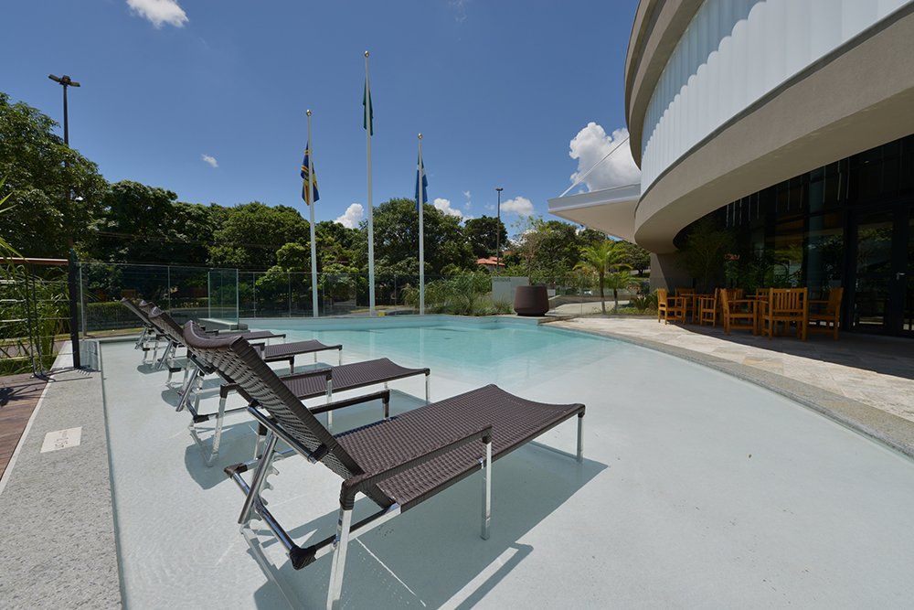 Espreguiçadeiras e piscina ao fundo