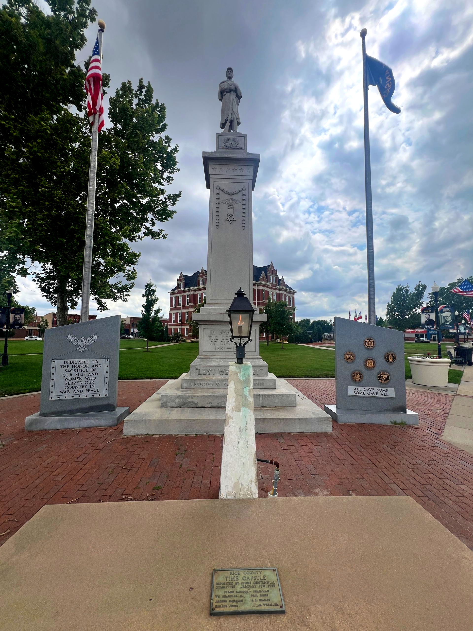 Civil War memorial monument with flags and wreaths in a park under cloudy skies