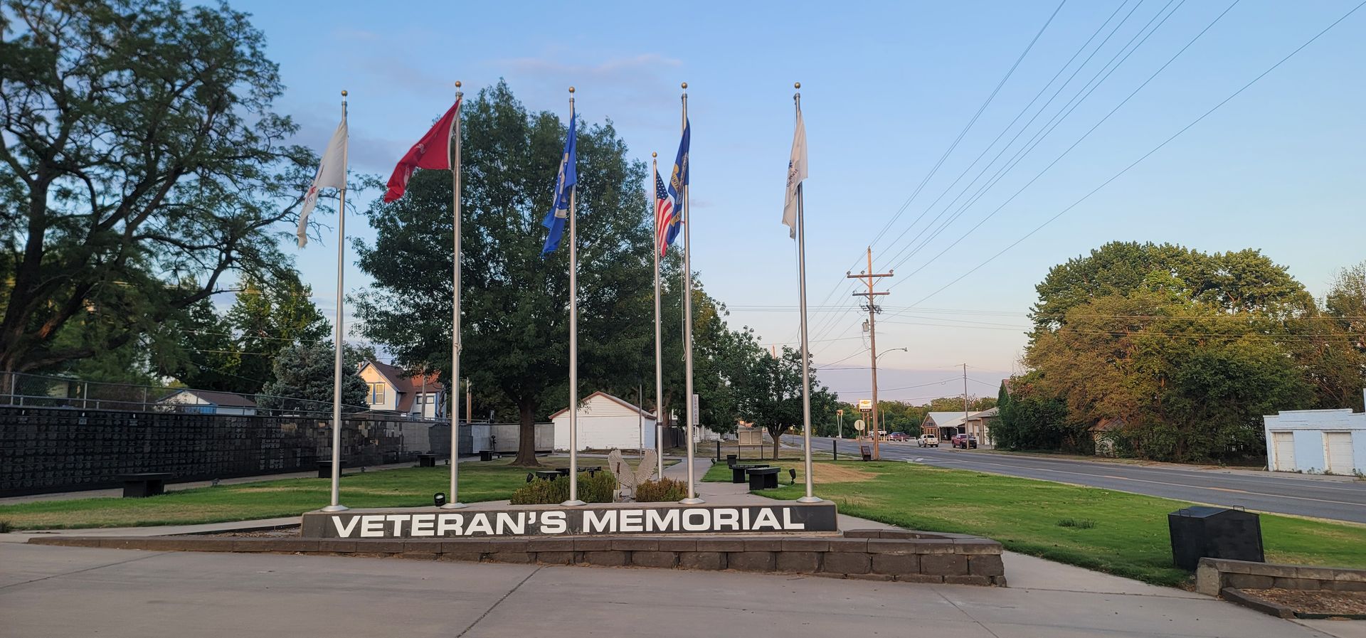 Veterans Memorial with flags and stone sign in a landscaped park