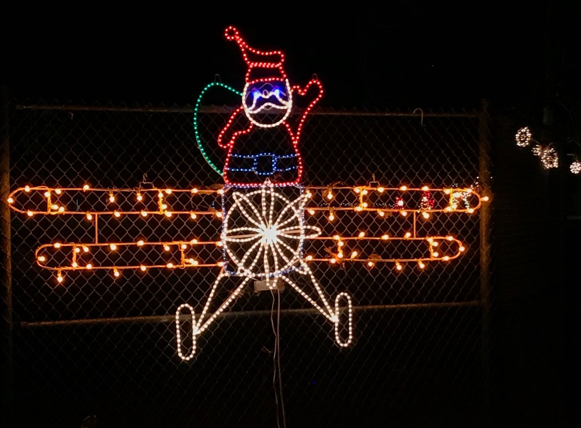 Santa made of lights riding a glowing tricycle at night