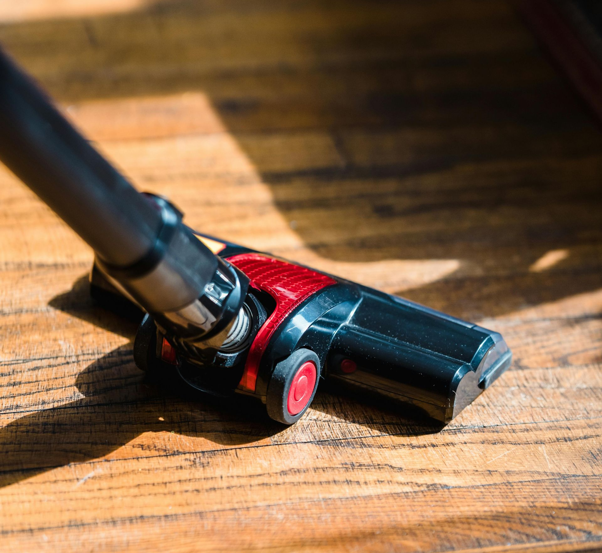 A person is using a vacuum cleaner to clean a carpet in a living room.