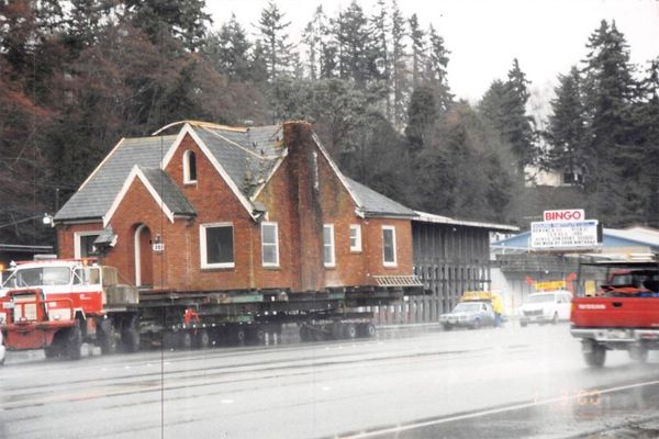 A large brick house is being moved down the road