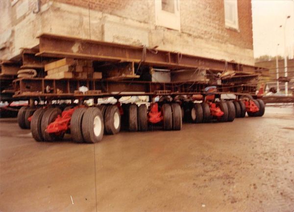 A large building is being moved by a row of trucks