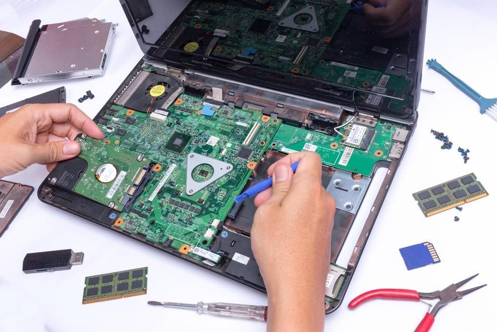 A Person is Repairing a Laptop Computer With a Screwdriver — River City Communications In Gloucester, NSW