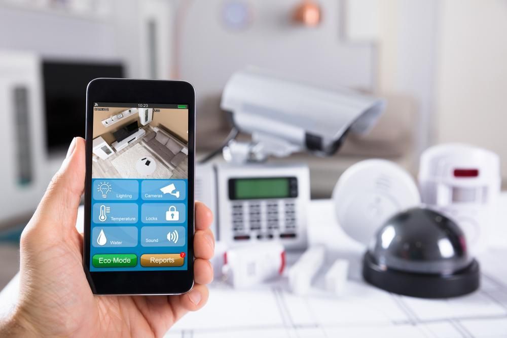 A Person is Holding a Smart Phone With a Security System on It — River City Communications In Melinga, NSW