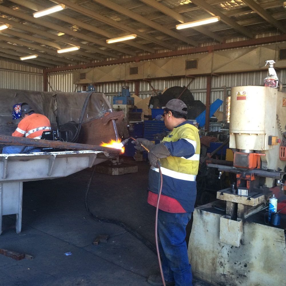 Men Welding Workers Repairing The Heavy Equipment On The Shop — Wright's Welding Operations In Cloncurry, QLD
