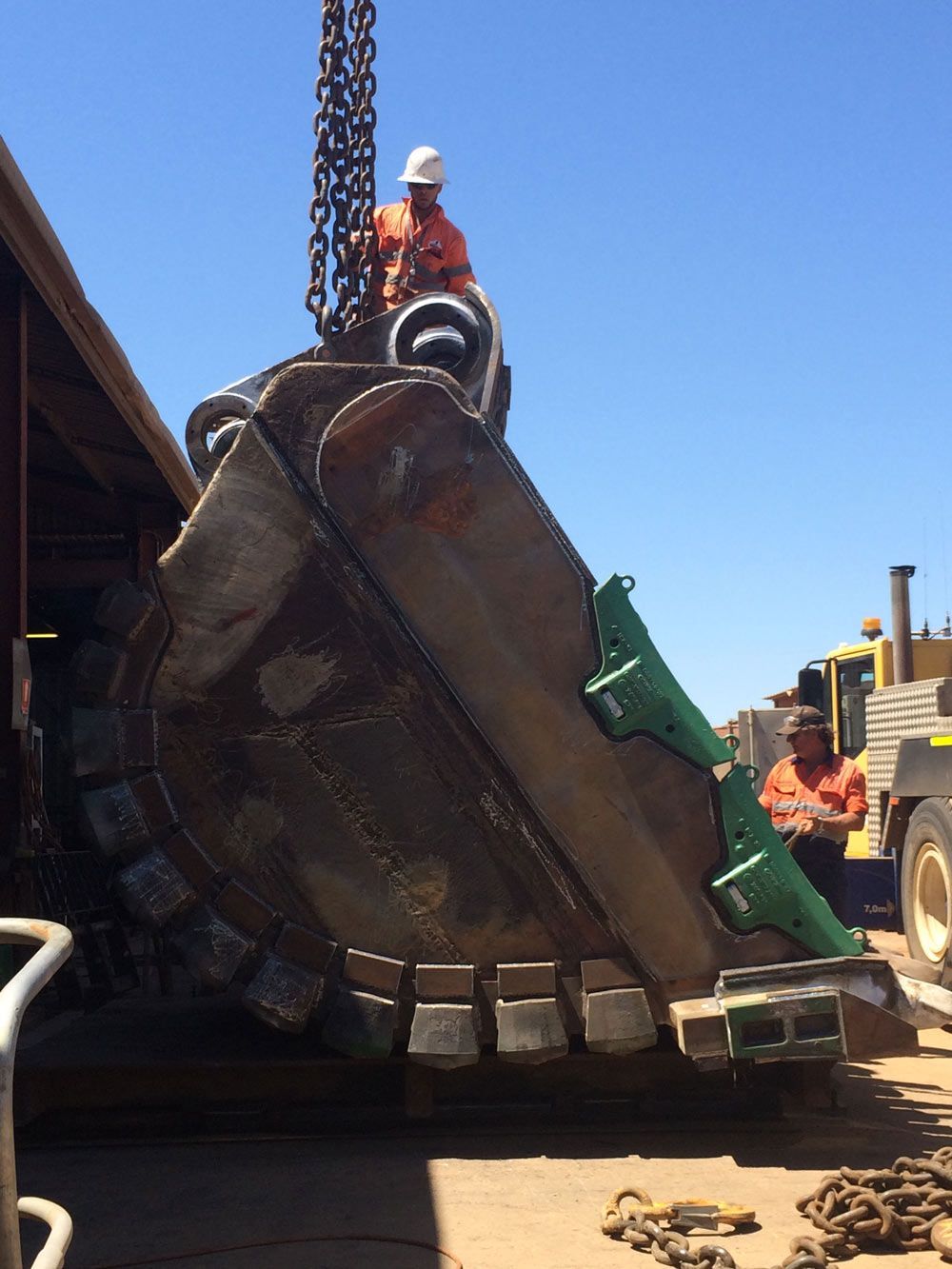 Two Male Workers Using Crane To Lifting The Heavy Bucket — Wright's Welding Operations In Camooweal, QLD