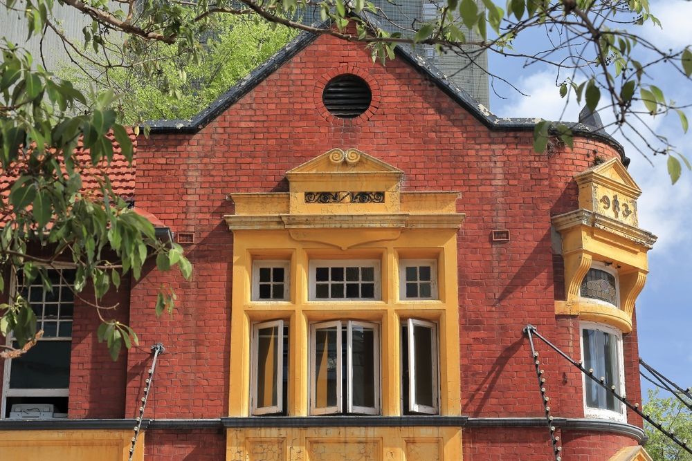 A Red Brick Building Facade With Yellow Trim — The Cheapy Shop in Old Bar, NSW