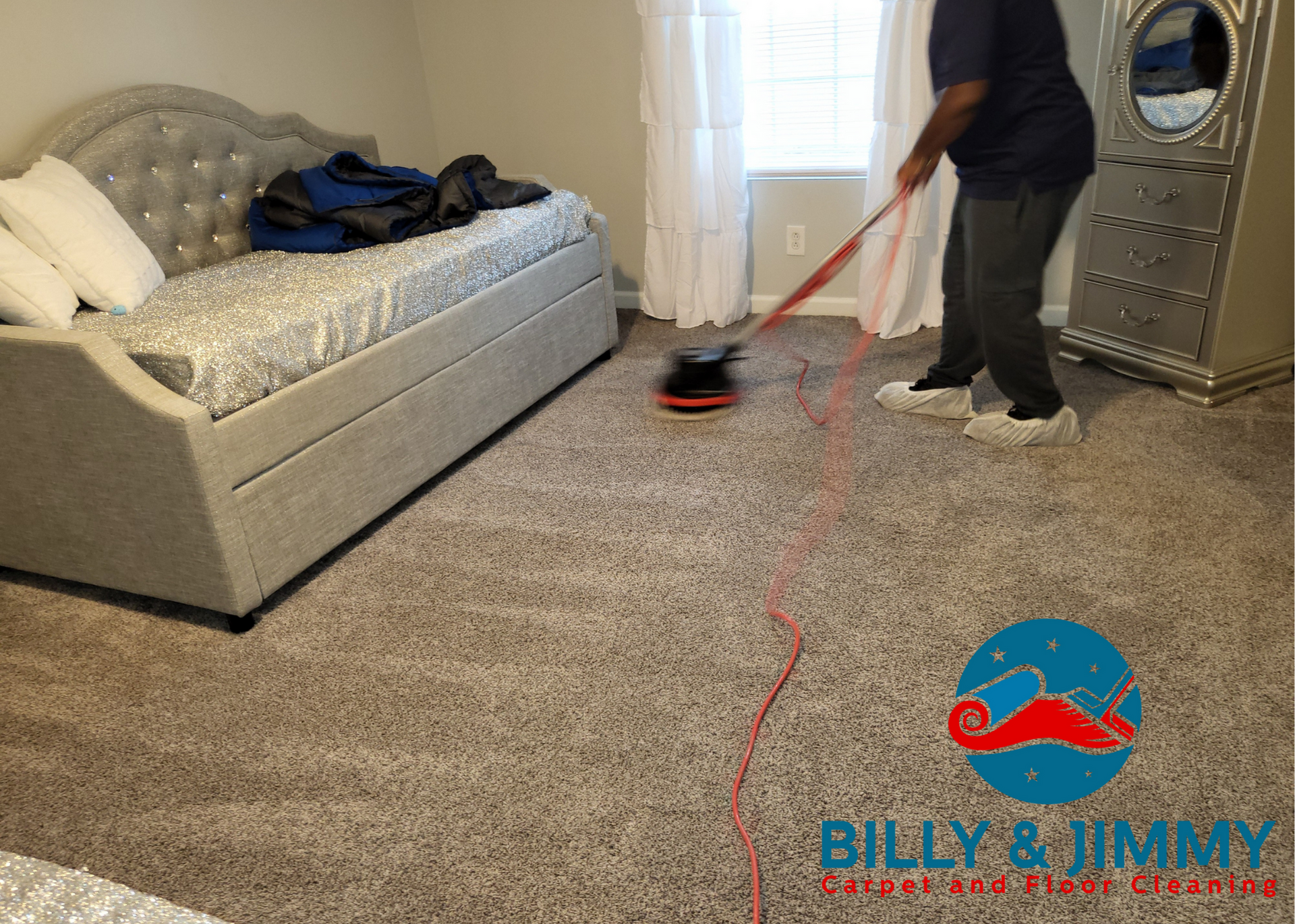 a man is cleaning a carpet in a bedroom with a vacuum cleaner .