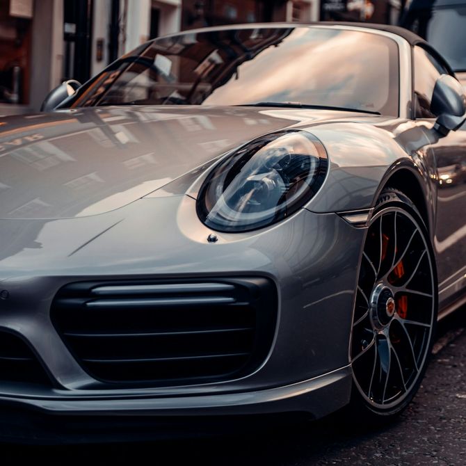 Gray sports car parked on a city street, close-up front view