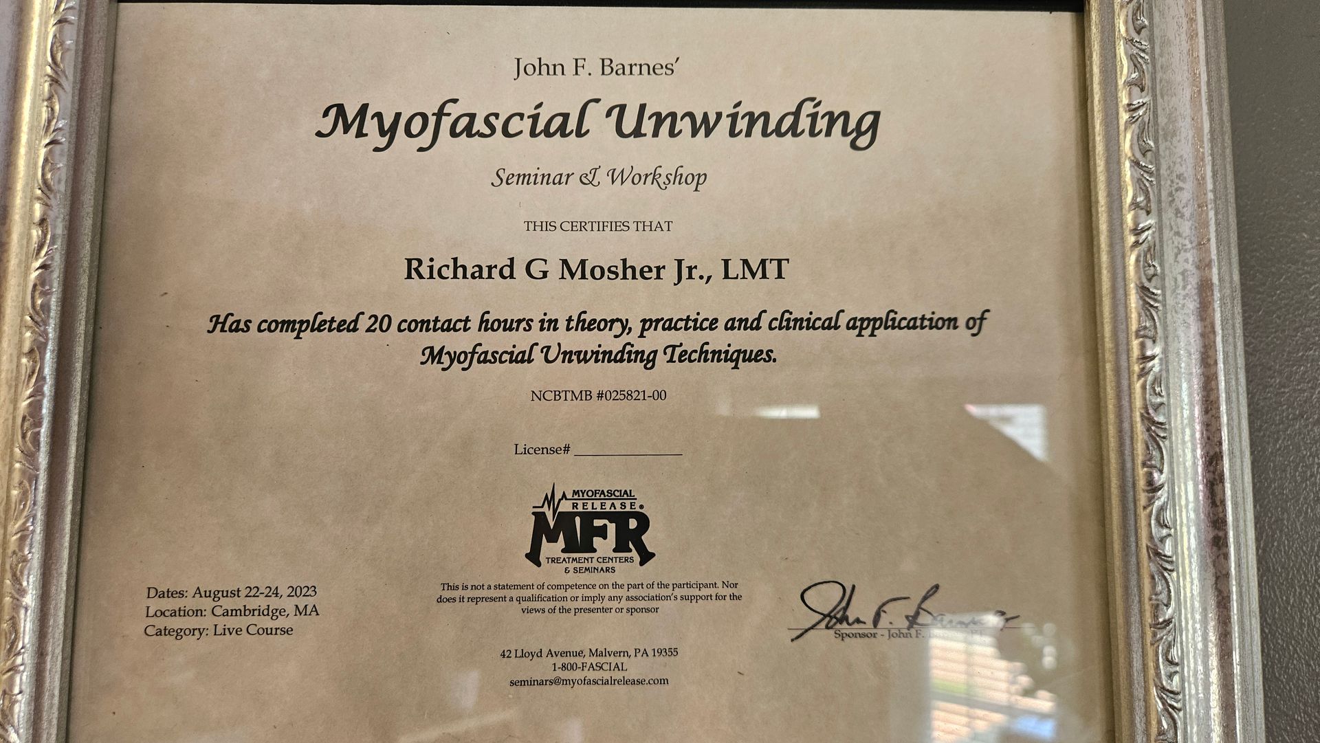 Framed certificate reading “Myofascial Unwinding” with text and signatures on a beige background