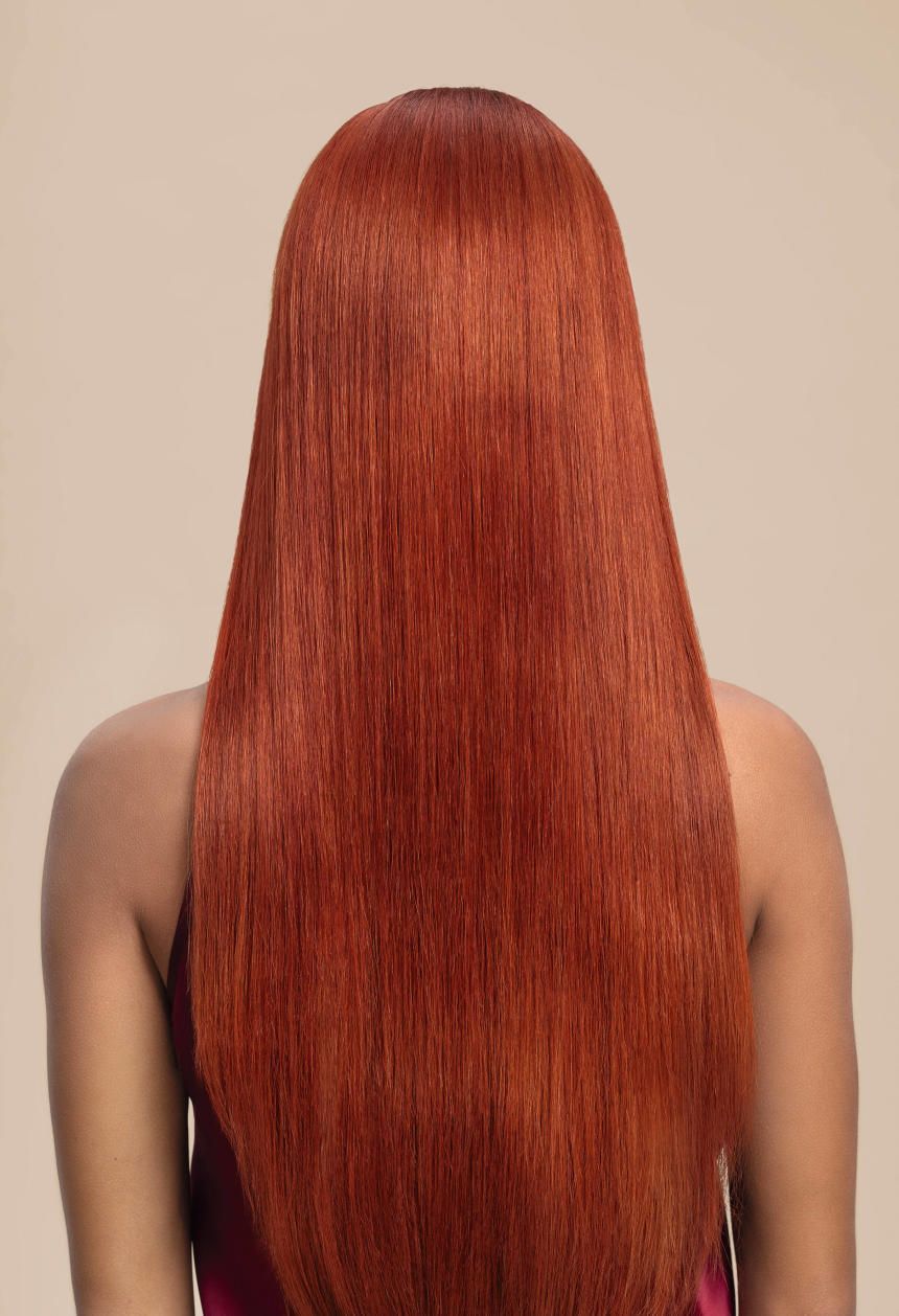 Back view of a person with long, straight copper-red hair against a beige background