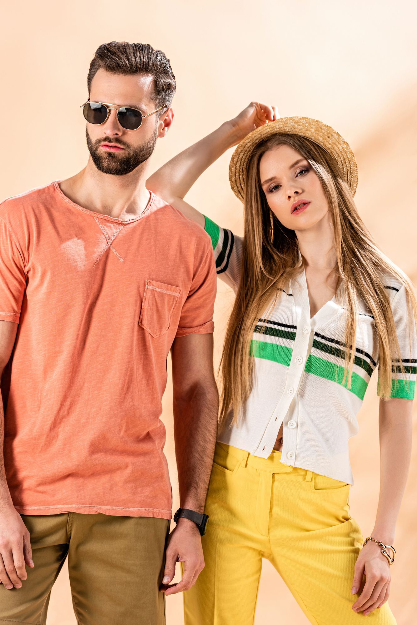Due modelle in posa con abiti casual colorati sullo sfondo caldo dello studio.