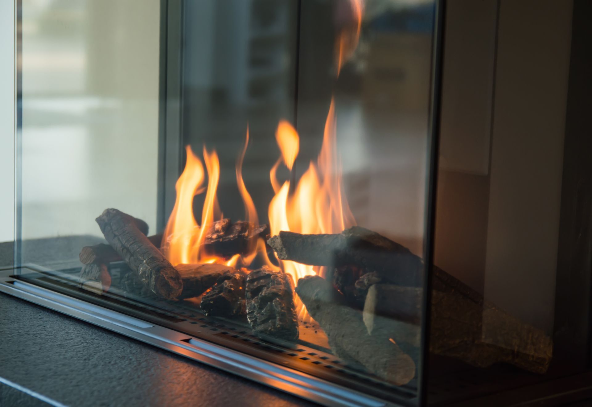 a fire burns in a glass fireplace.