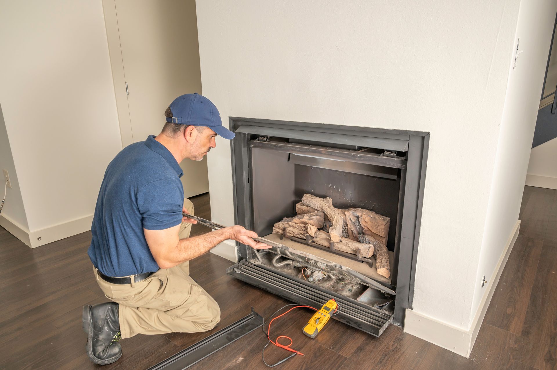 Technician inspecting gas fireplace components Technician inspecting gas fireplace components