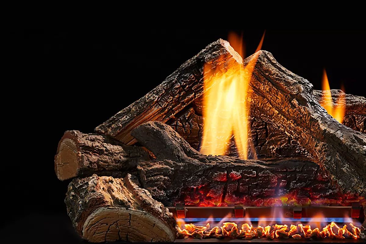 Gas fireplace with orange flames rising from ceramic logs against black background.