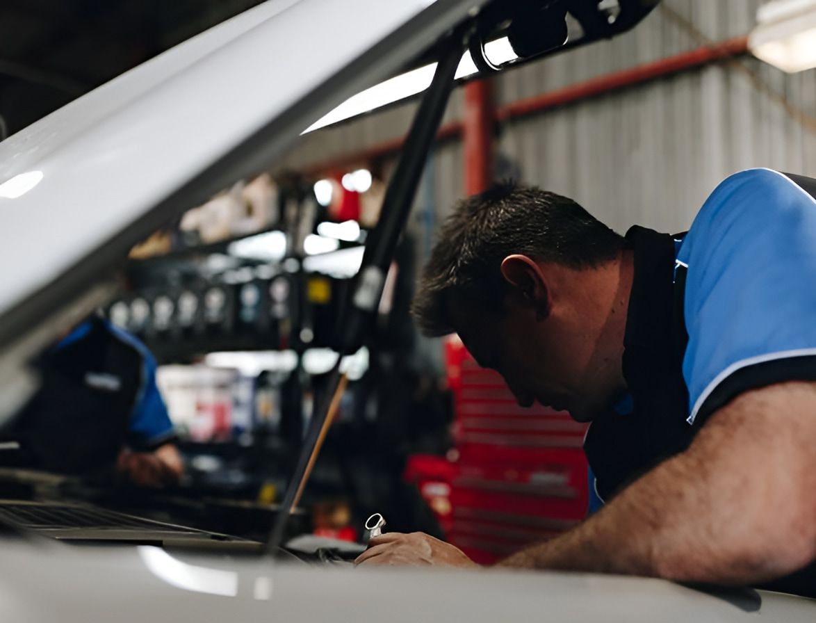 A Man is Working on a Car in a Garage — Protec Mechanical Repairs In Taree, NSW