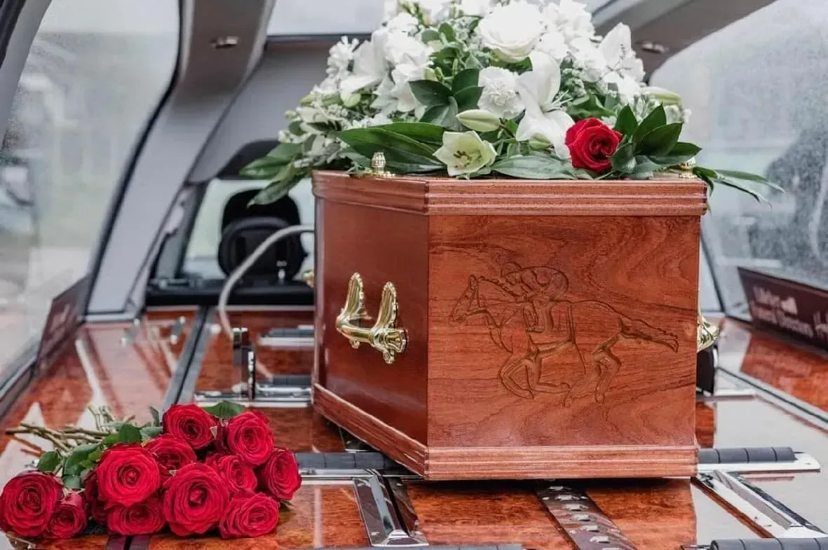 A statue of a horse is sitting on a table next to a bouquet of flowers.