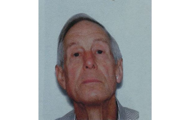 Close-up of a serious-faced man against a plain light background.