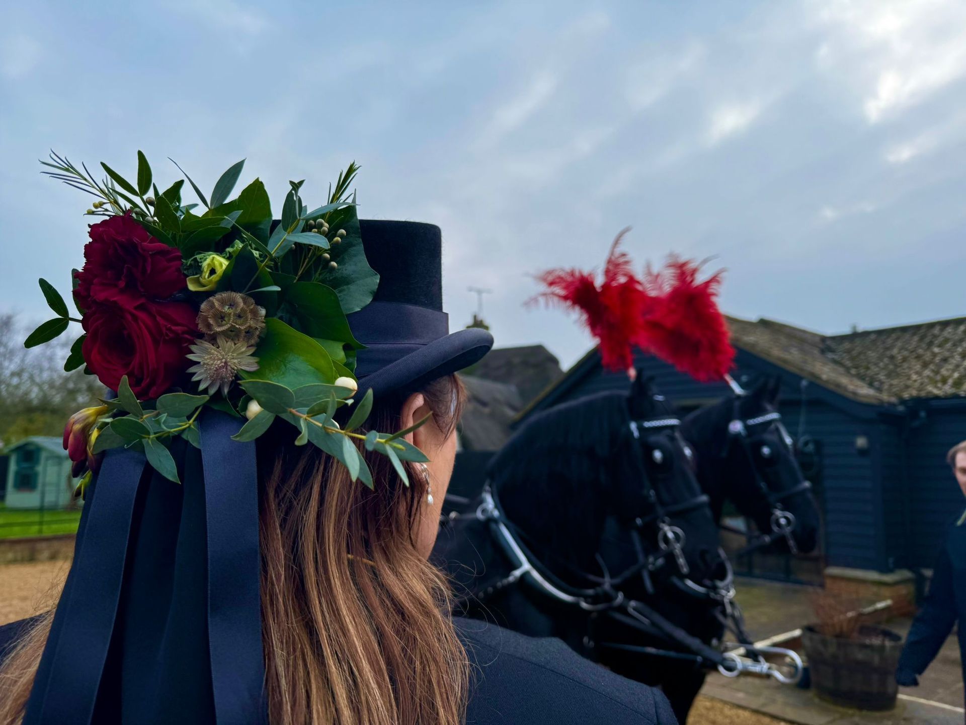 A woman wearing a top hat with flowers on it