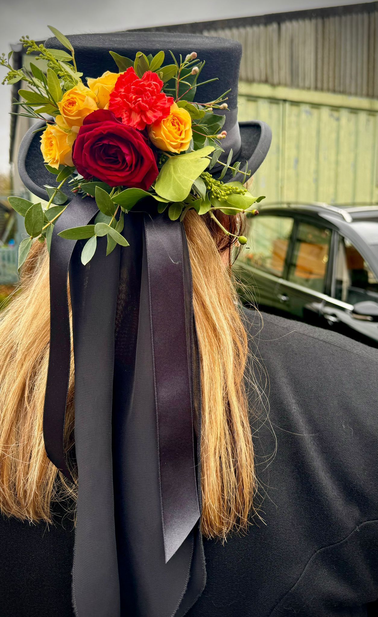 A woman wearing a top hat with flowers on it