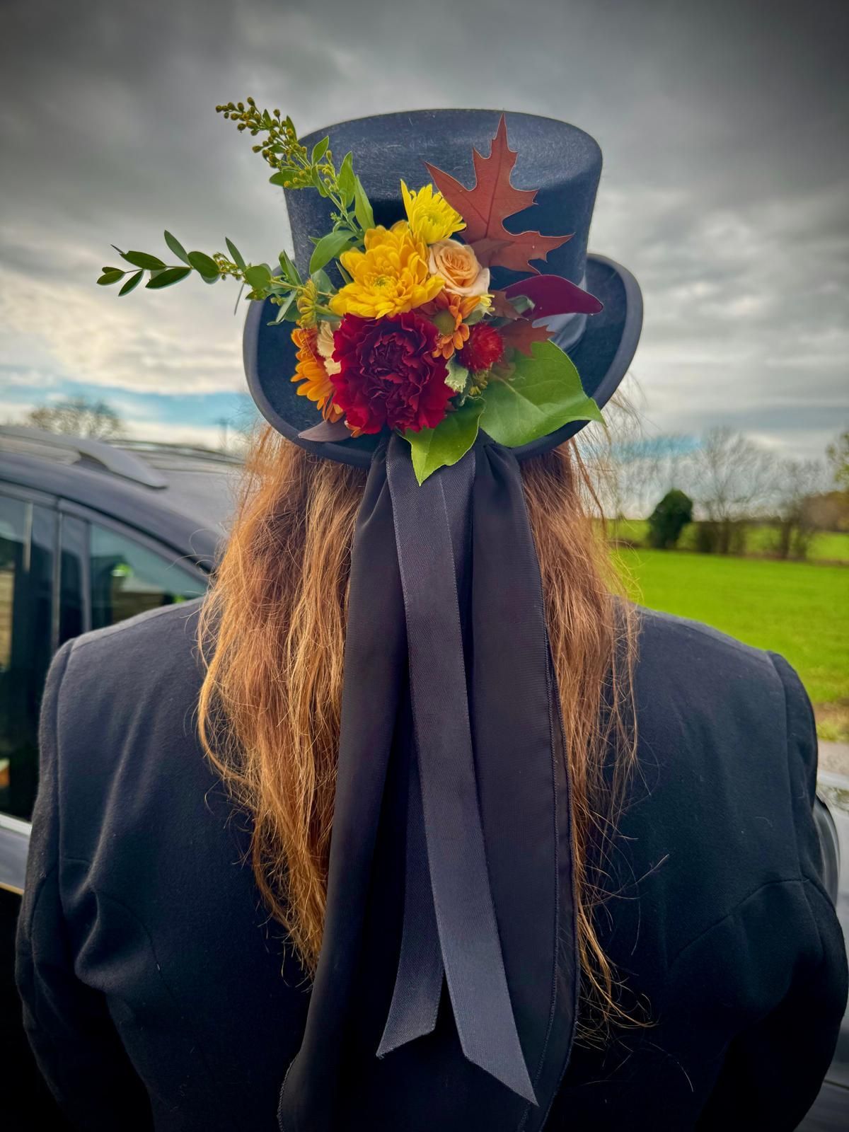 A woman wearing a graduation cap with flowers in her hair