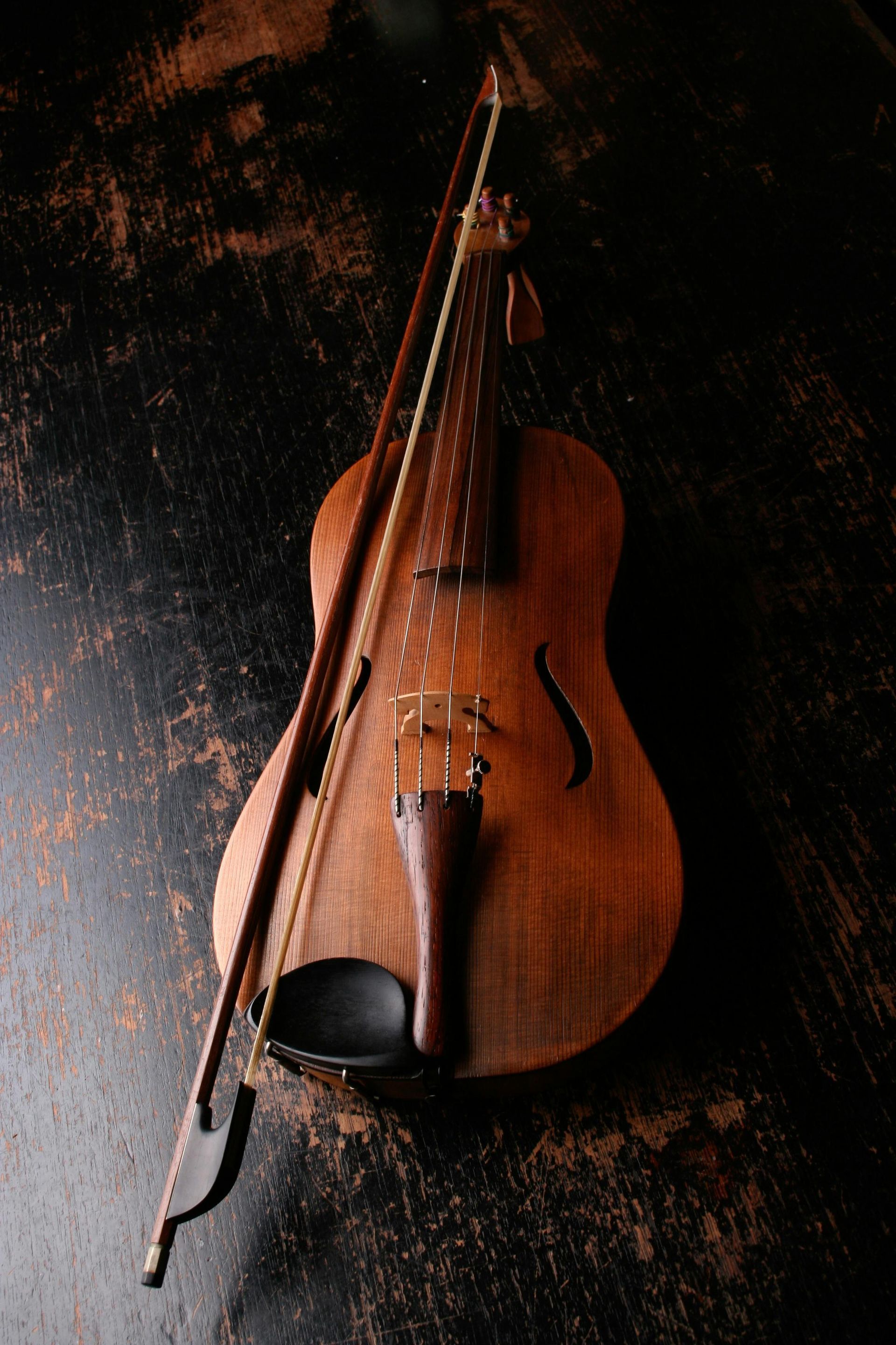 A violin with a bow on a black surface