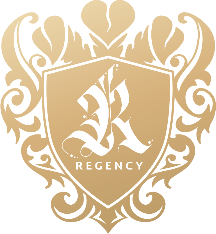Gold ornate Regency crest with floral scrollwork and shield emblem on a white background