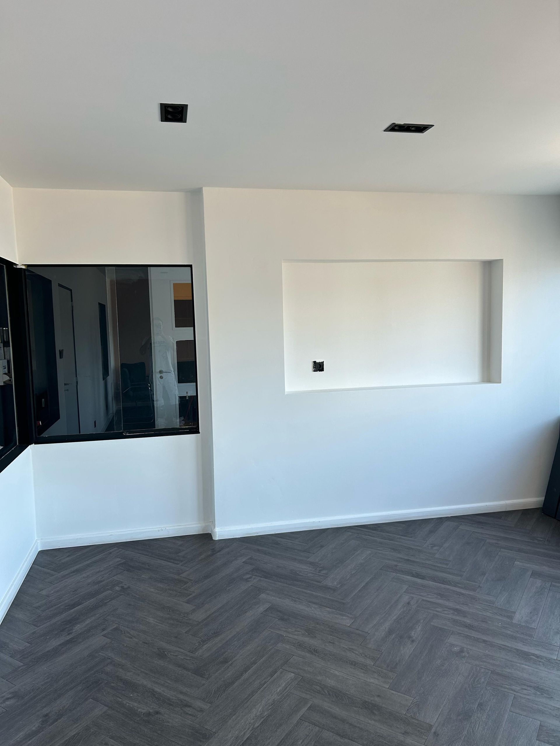 Een woonkamer met een flatscreen-tv aan de muur