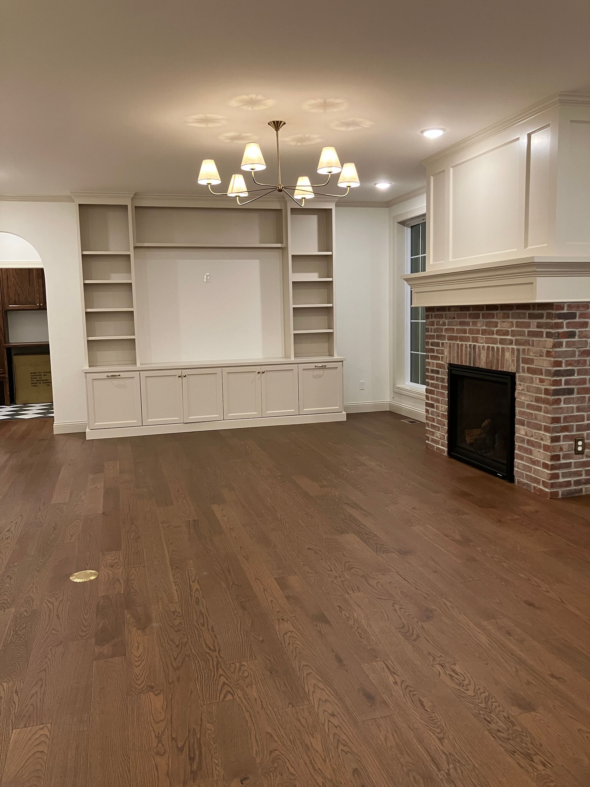 Post Construction recently cleaned wooden floors free of drywall dust in an open empty room ready for homeowners to move in.