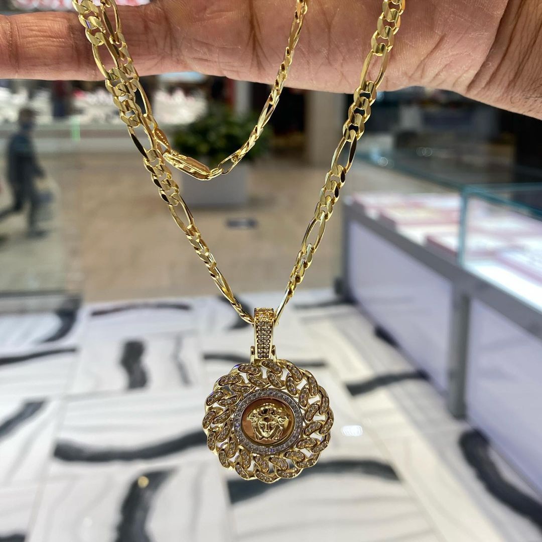 A person is holding a gold necklace in their hand