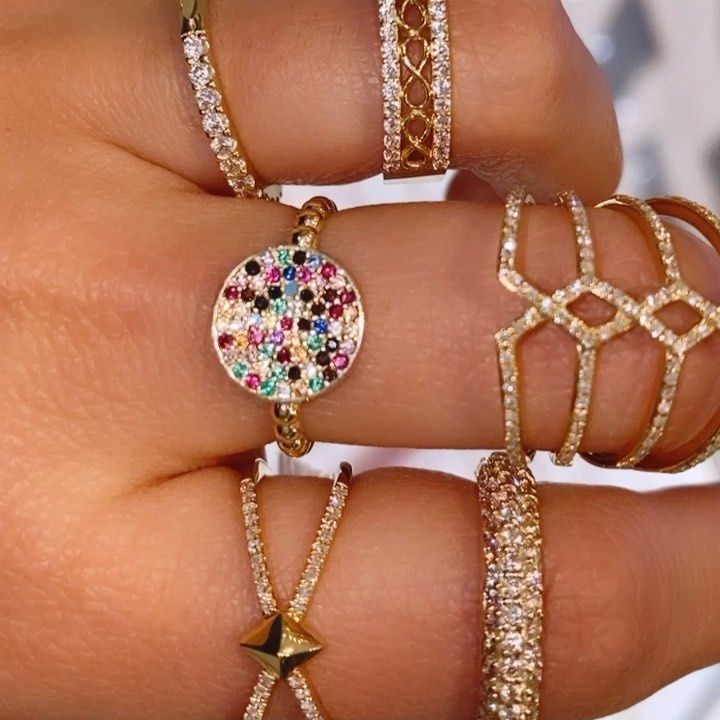 A close up of a woman 's hand with many rings on her fingers