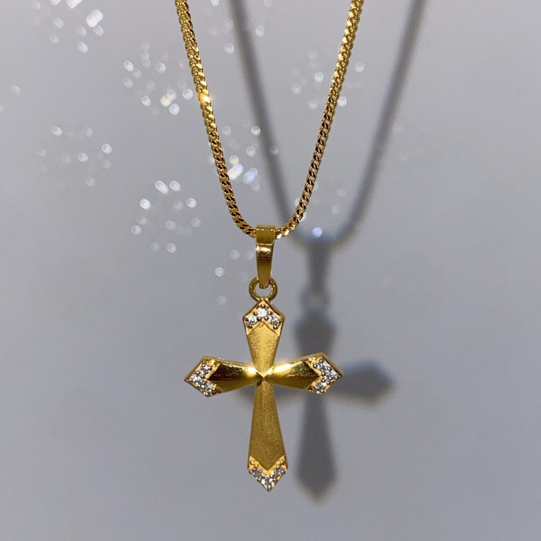 A gold chain with a cross pendant on it
