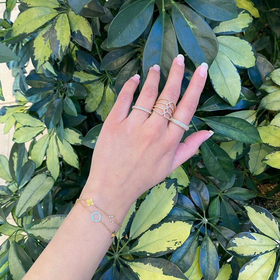 A woman 's hand with a bracelet and rings on it