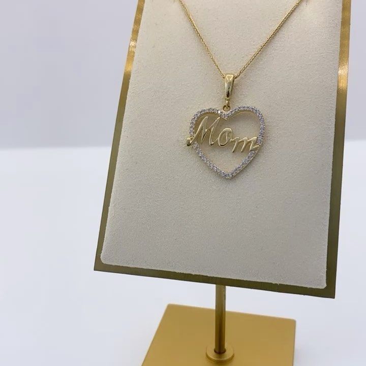A necklace with a heart shaped pendant that says mom