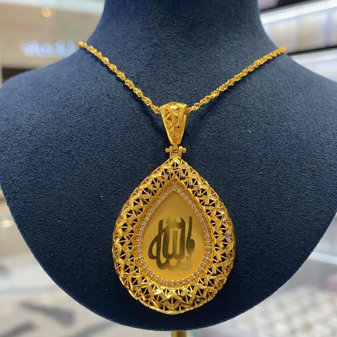 A gold necklace with arabic writing on it