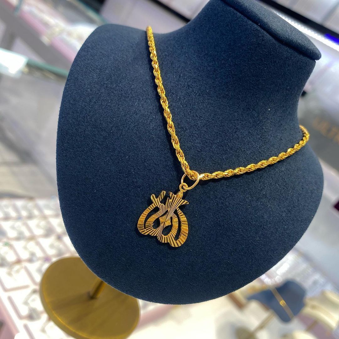 A gold necklace is on a mannequin in a store